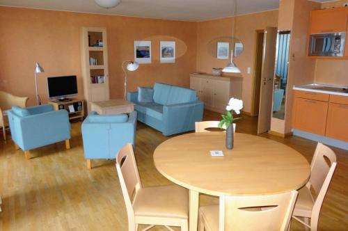 a living room with a table and blue chairs at Ferienpark am Glubigsee in Wendisch Rietz