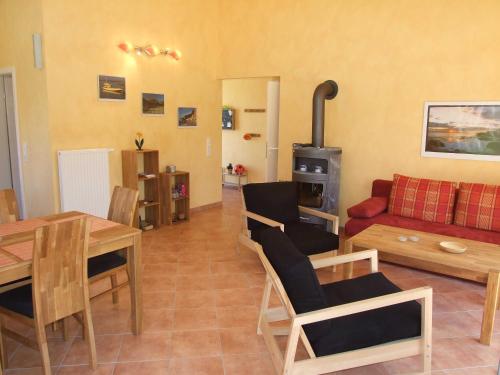 a living room with a couch a table and a stove at Ferienhaus Kajuete in Schönhagen