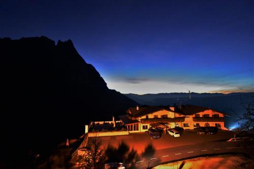 a house on a hill with a mountain in the background at Hotel Gstatsch in Alpe di Siusi