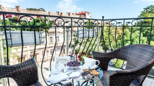 a table with a tea set on a balcony at Frederic Koklen Boutique Hotel in Odesa