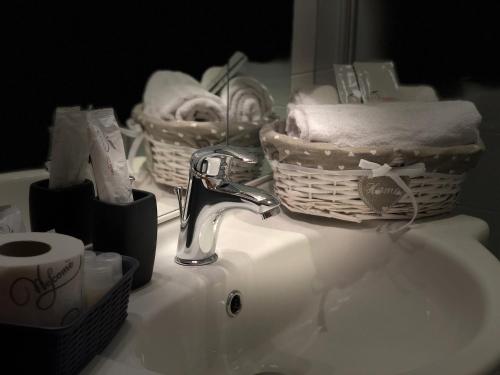 a bathroom sink with a basket of towels and a faucet at Saint Peter Inn in Rome