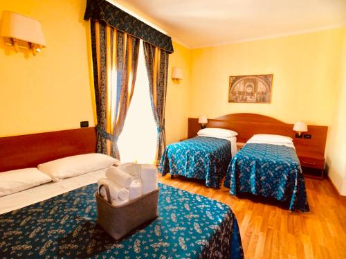 a hotel room with two beds and a window at Saint Peter Inn in Rome