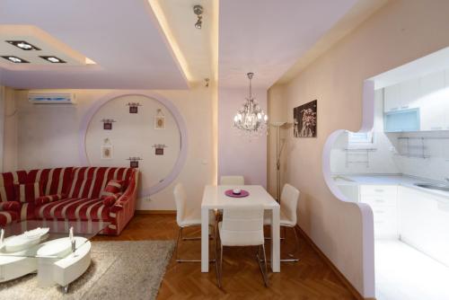 un soggiorno con divano rosso e tavolo di Garni Hotel Crystal a Kraljevo