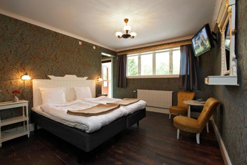 een slaapkamer met een bed, een tafel en een stoel bij Ardrebo B&B in Ljugarn