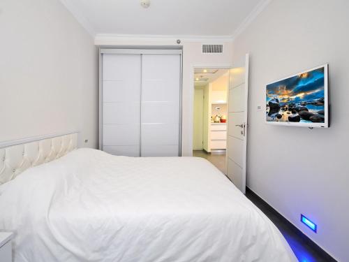 a white bedroom with a large white bed at מגדלי המלכים נופש משפחתי in Tiberias