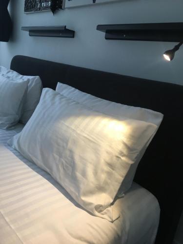 a bed with white sheets and a pillow on it at Les lofts de Styliste in Brussels