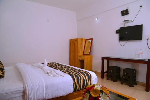 a bedroom with a bed and a table with speakers at Pine Tree Munnar in Munnar