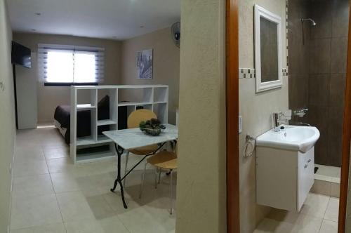 a bathroom with a sink and a table in a room at Aylen Departamentos en Pinamar NO GRUPO DE JOVENES in Pinamar