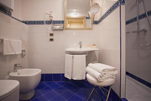 a bathroom with a sink and a toilet and a shower at Hotel Cavour in Bologna