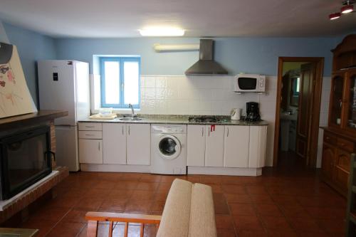 a kitchen with white cabinets and a washer and dryer at Casa Pedroso in Noja