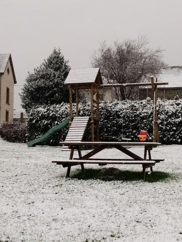 a wooden playground in a snow covered yard at La Métairie in Houffalize