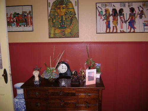 a room with a red wall with a clock on a dresser at Lakelawn B&B and Motel in Yarmouth