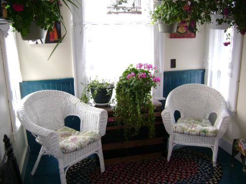 two wicker chairs sitting in a room with flowers at Lakelawn B&B and Motel in Yarmouth