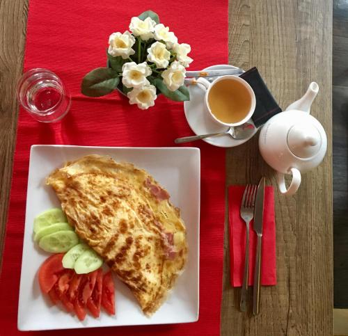 a omelet on a plate with a cup of coffee and fruit at Family Hotel Agoncev in Sofia