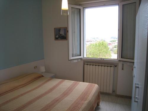 una camera con un letto e una grande finestra di Appartamento Adriatico a Cesenatico