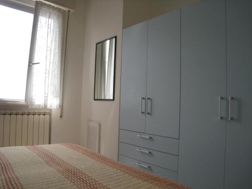una camera con armadi bianchi e un letto di Appartamento Adriatico a Cesenatico
