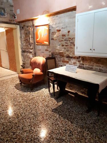 a living room with a table and a chair at Ai Boteri in Venice