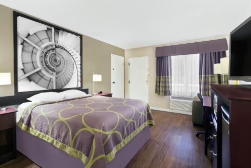 a hotel room with a bed and a desk at Super 8 by Wyndham Ellenton Bradenton Area in Ellenton