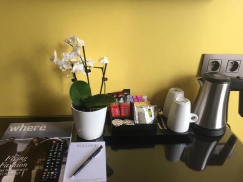 a desk with a remote control and flowers on it at Hôtel Orchidée in Paris