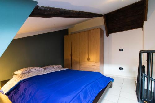 una camera con letto blu e armadi in legno di Bilo Bellezia a Torino