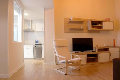a living room with a chair and a desk with a television at APLUS Apartamentos, Old Town Benidorm in Benidorm