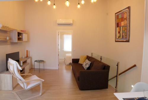 a living room with a couch and a chair at APLUS Apartamentos, Old Town Benidorm in Benidorm