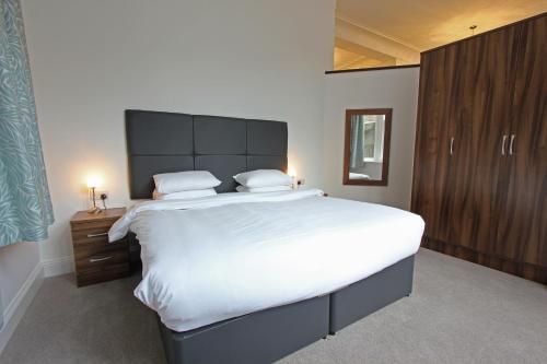 um quarto com uma cama grande e lençóis brancos em The Castle Collection 14 Cook Street em Liverpool