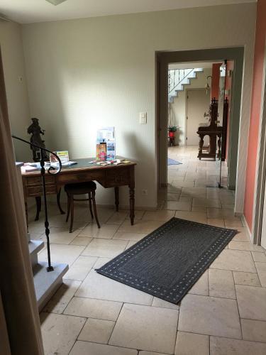 a room with a desk and a table with a rug at Logies Ternier in Nieuwpoort