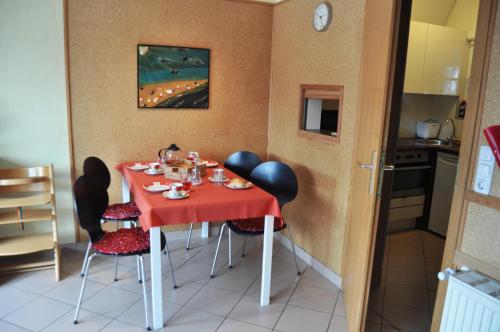 a dining room with a red table and chairs at Ferienhaus Exner hinter dem Deich in Cuxhaven