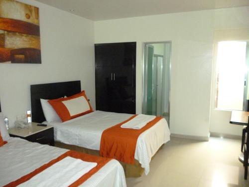 a hotel room with two beds and a window at Hotel Empresarial in Paraíso