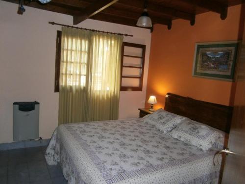 a bedroom with a large bed and a window at "Mi Casa" in Villa General Belgrano