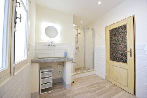 ein Bad mit einem Waschbecken, einer Dusche und einem Spiegel in der Unterkunft Casa Nora in Lucca