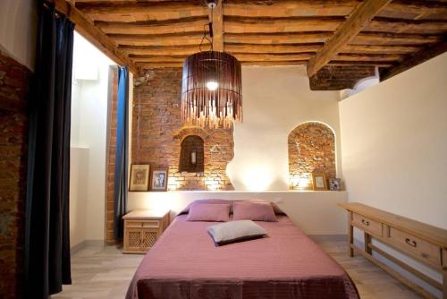 Schlafzimmer mit einem Bett und einem Kronleuchter in der Unterkunft Casa Nora in Lucca