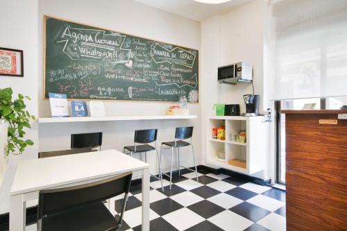 a classroom with a chalkboard on the wall and a table and stools at Pension Mesones in Granada