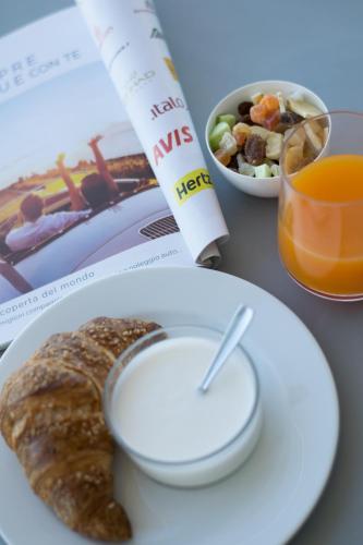 Una mesa con un plato de comida, un cigarrillo y una bebida. en Hotel Sole, en Montesilvano