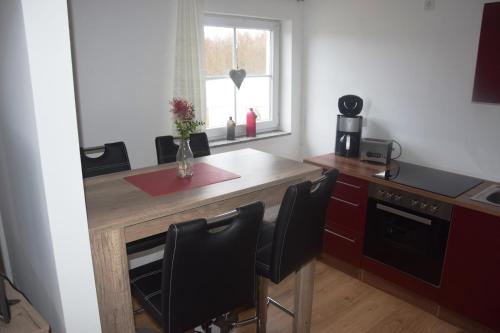 a kitchen with a wooden table and black chairs at Ferienresort Texas MV in Kirch Jesar