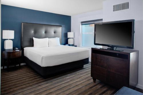 謝爾頓的住宿－謝爾頓凱悅豪斯酒店，一间卧室配有一张床和一台平面电视