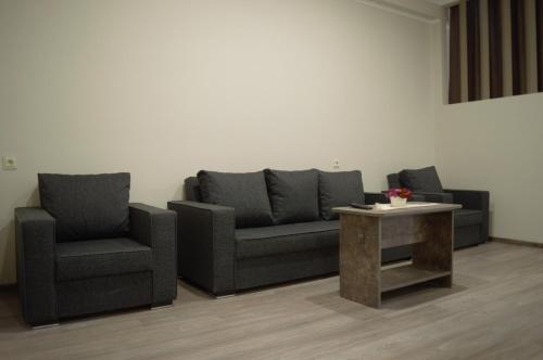 a living room with a couch and two chairs and a table at Hotel Nabadi in Tbilisi City