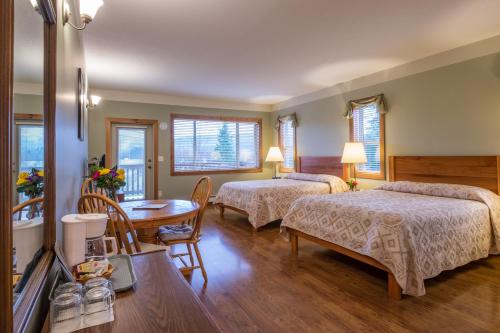 een hotelkamer met 2 bedden en een tafel bij Kiwi Cove Lodge in Ladysmith