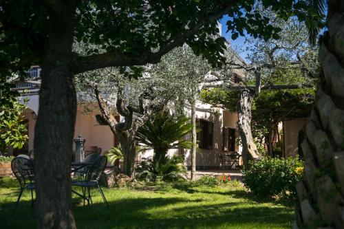 マッサ・ルブレンセにあるVilla Caprileの椅子と木のある庭のある家