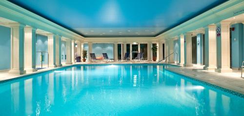 a swimming pool with blue water in a building at Hythe Imperial Hotel, Spa & Golf in Hythe