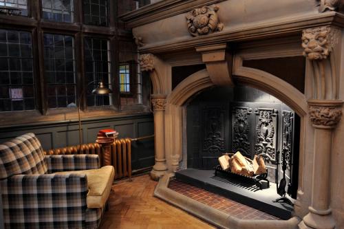 a living room with a fireplace and a couch at The Crown Manor House Hotel in Lyndhurst