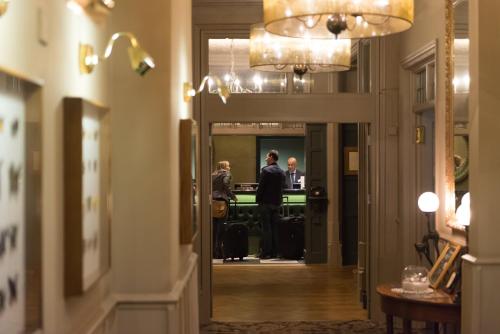 a man and a woman standing in a hallway at The Crown Manor House Hotel in Lyndhurst