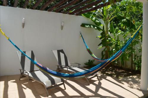two chairs and a hammock on a patio at Casa Mango in Valladolid
