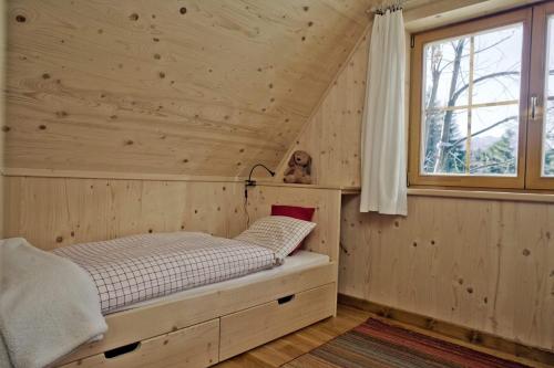 ザコパネにあるDomek Pod Sosnąの窓付きの木造の部屋のベッド1台