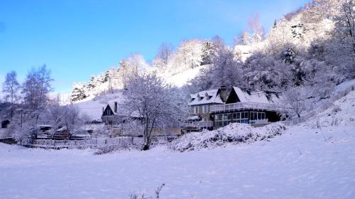 a house covered in snow on a snow covered hill at Le Solayan in Couledoux