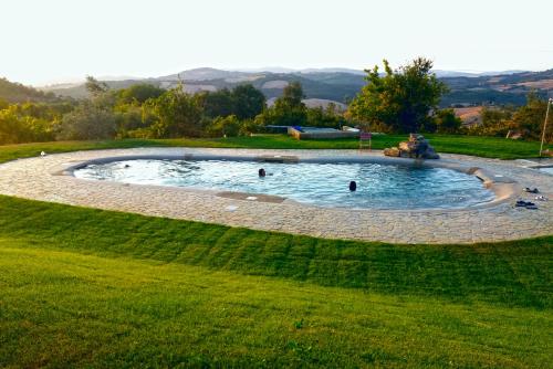 uma piscina circular num campo relvado com pessoas nele em Agriturismo Le Canterie em Radicondoli