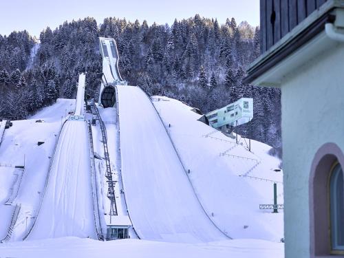 a ski slope with a ski lift in the snow at Olympiahaus in Garmisch-Partenkirchen