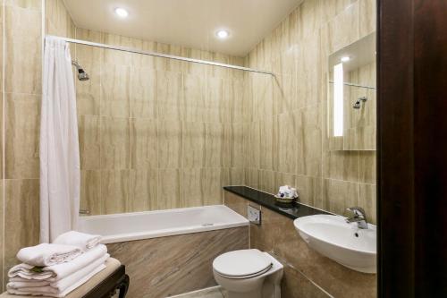 a bathroom with a sink and a toilet and a bath tub at Doxford Hall Hotel And Spa in Alnwick