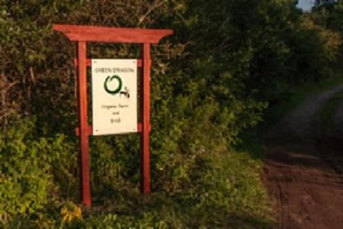 ein Schild an der Seite einer unbefestigten Straße in der Unterkunft Green Dragon Organic Farm and B&B in Tatamagouche